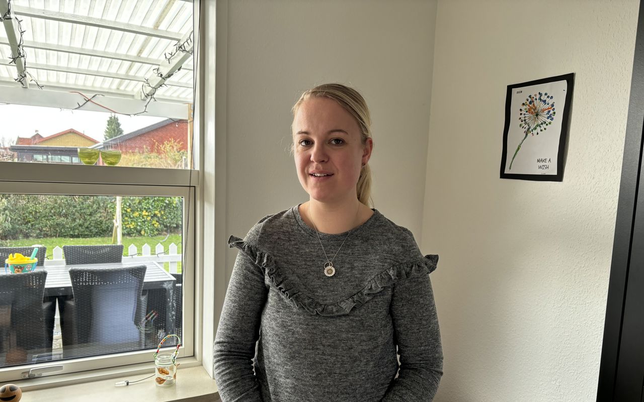 Kvinde står foran vindue