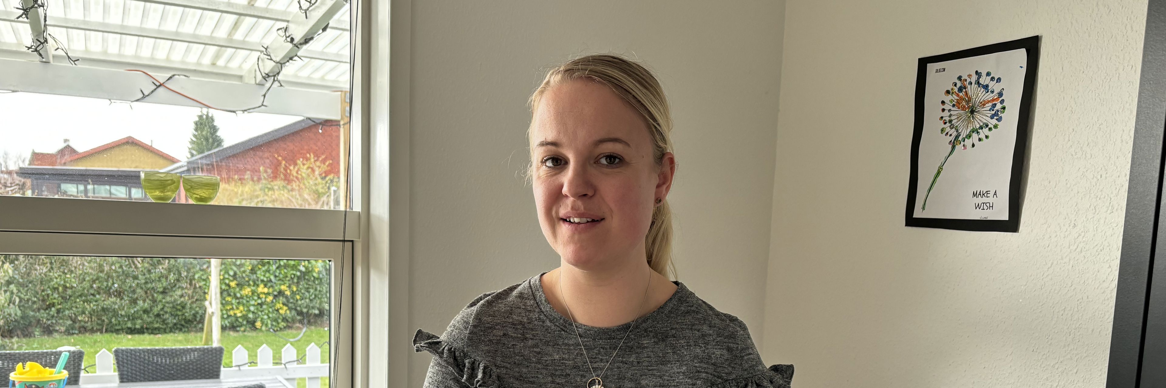 Kvinde står foran vindue
