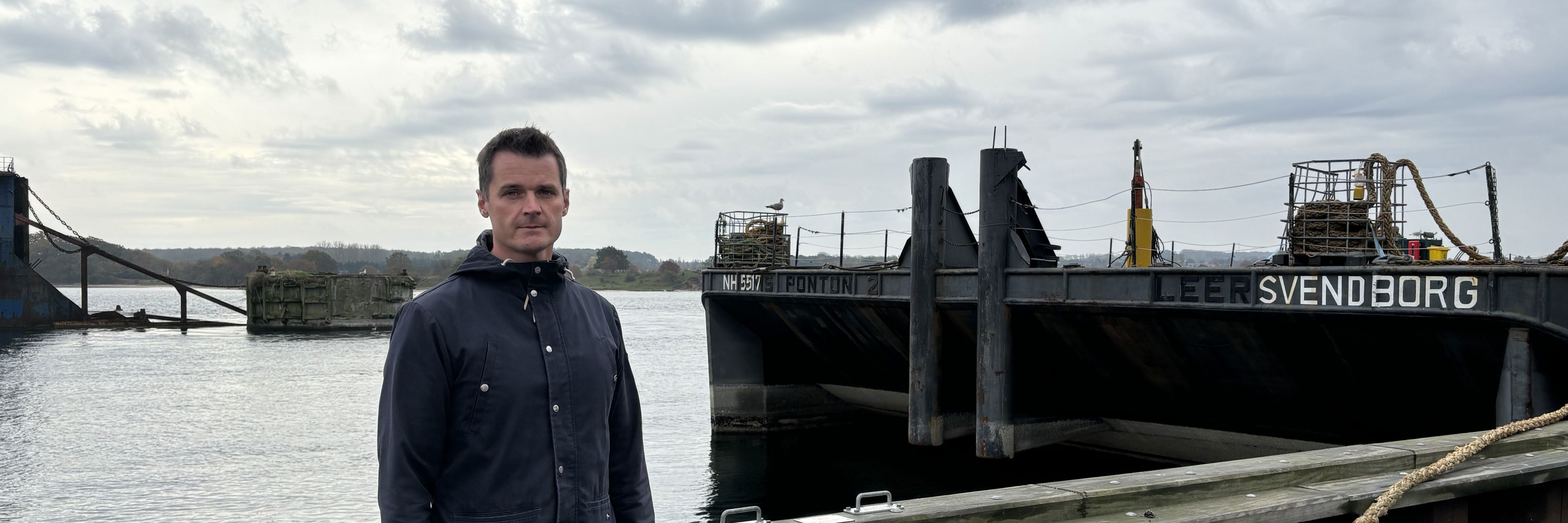 Mand står på havnen