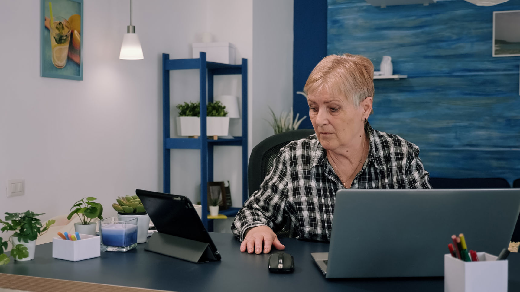 Ældre kvinde arbejder foran en computer